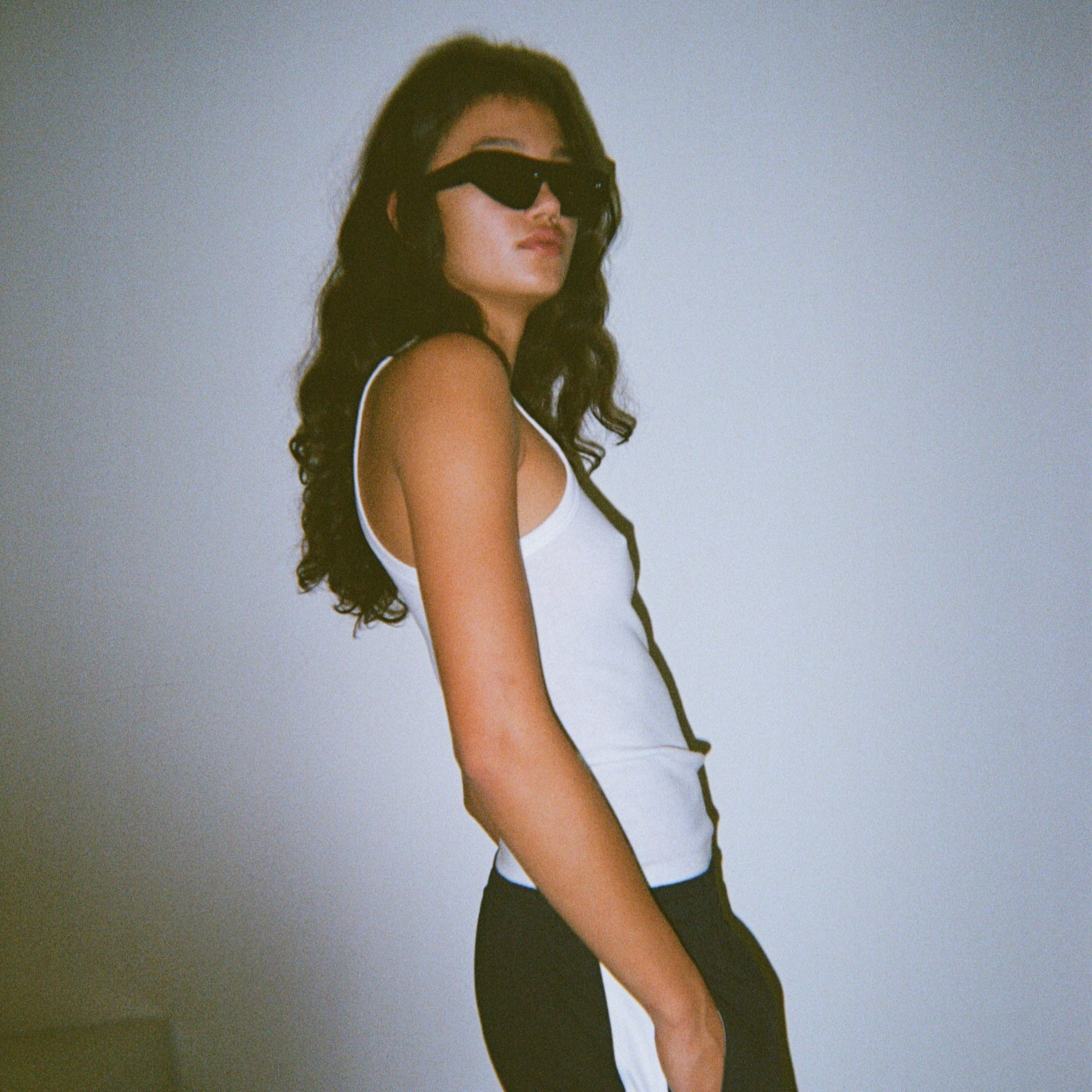 Girl with brown long hair white tank top bassike clothing